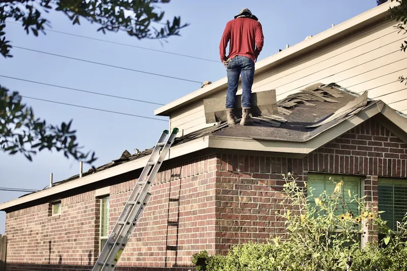 Professional roofer working on a residential roof in Gonzales